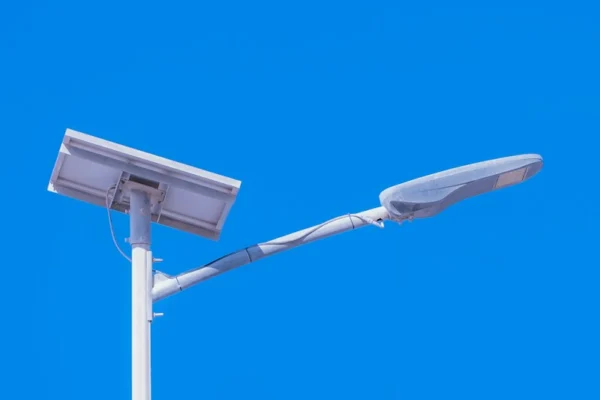 Solar-powered streetlight against a bright blue sky