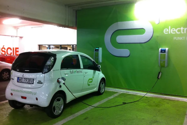 Carro elétrico conectado a um carregador em garagem de edifício