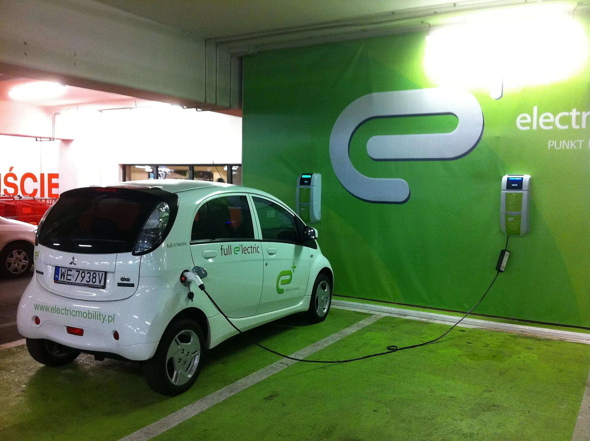 Carregador de Carro Elétrico em Prédio: Regras no ES e SP 1 Carro elétrico conectado a um carregador em garagem de edifício