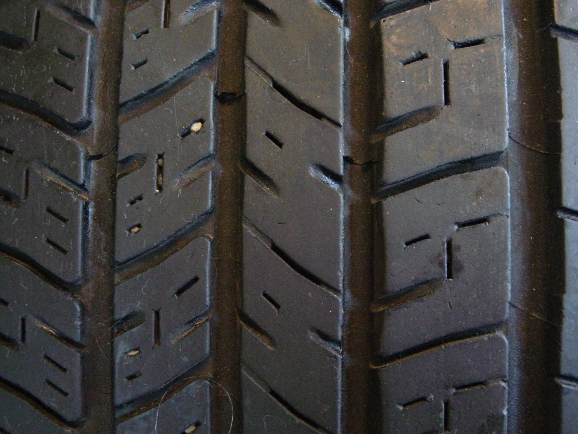 Pneus de Carro Elétrico Desgastam Mais Rápido? 1 Close da banda de rodagem de um pneu usado